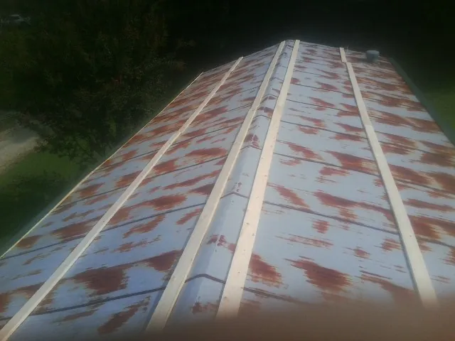 Rusted metal roof panels with new wood purlins before replacement — Storm Damage Roof Repair in Copiague by Roofing Brothers