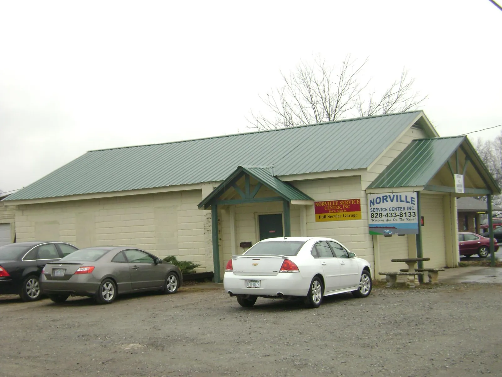 Green metal roof on a service garage with a covered entry in Copiague