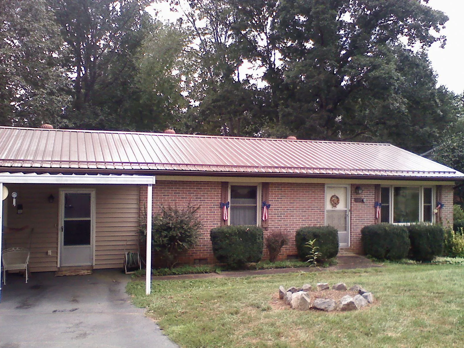Bronze metal roof and carport on a brick ranch home — Roof Repair work by our crew in Copiague